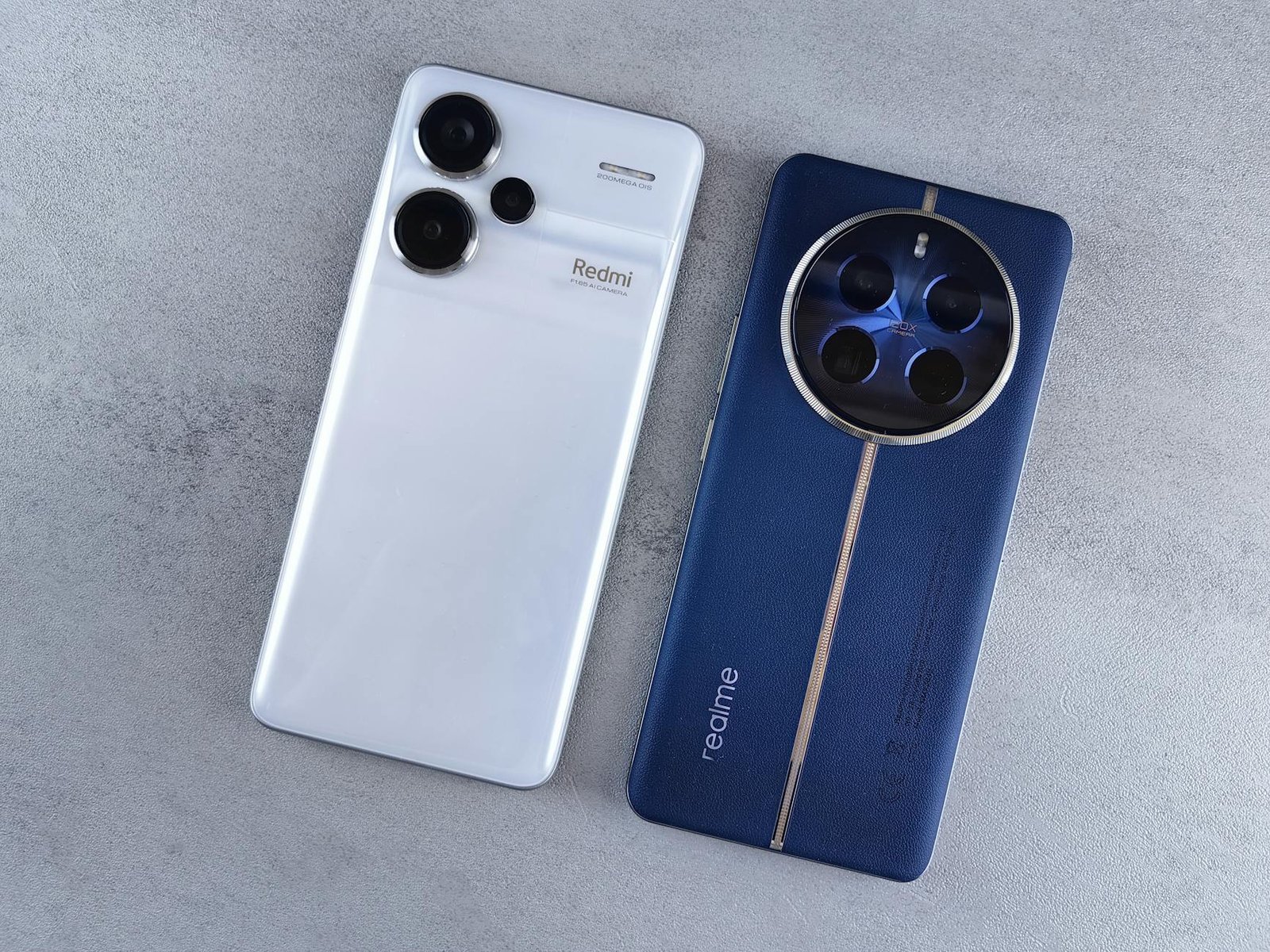 Two smartphones, one white and one blue, displayed on a textured grey background.