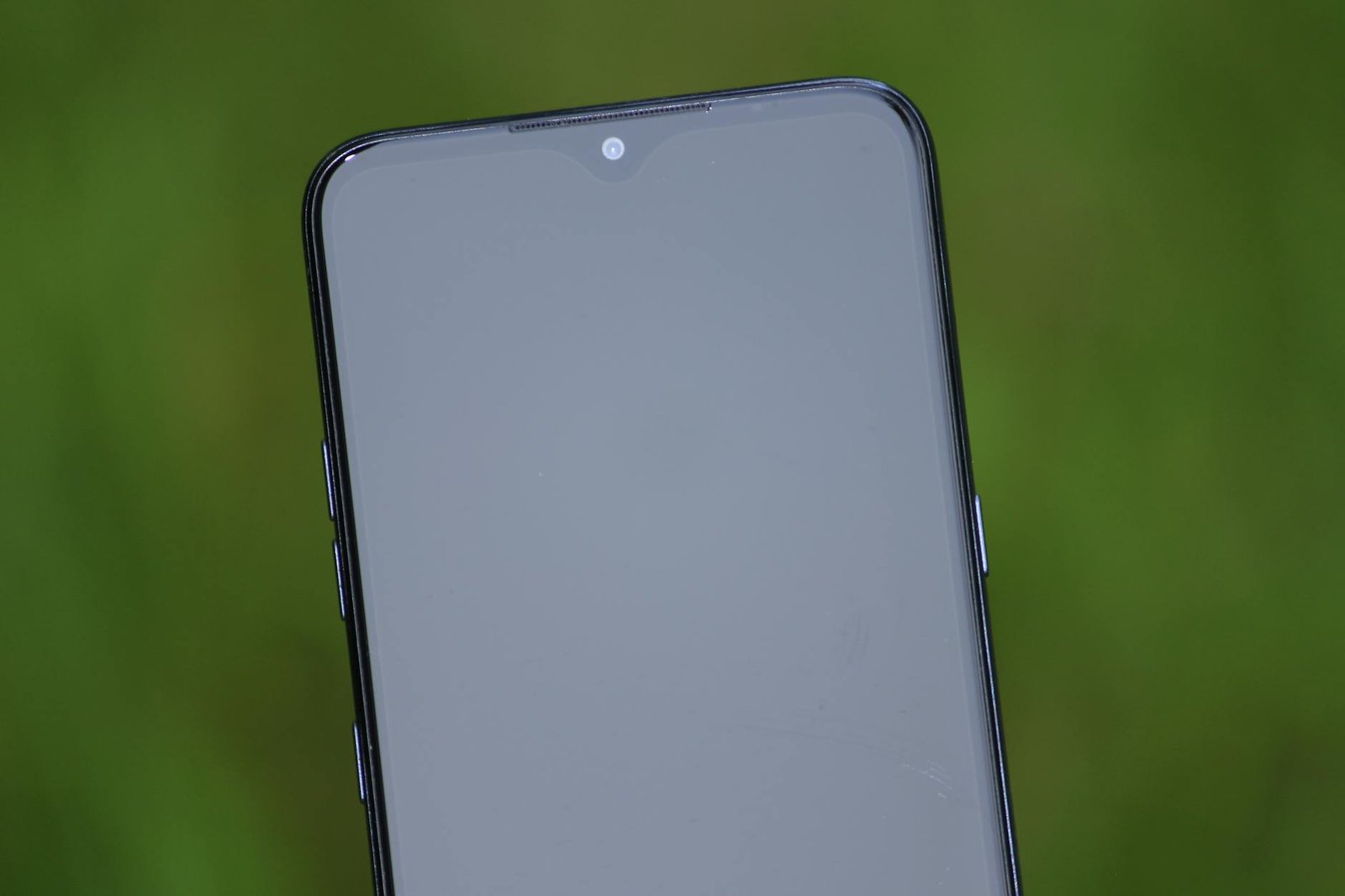 Close-up view of a smartphone screen with a green background, ideal for tech themes.