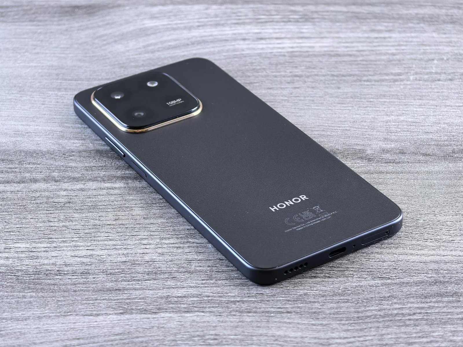 Close-up of a modern smartphone with a sleek design on a wooden surface.