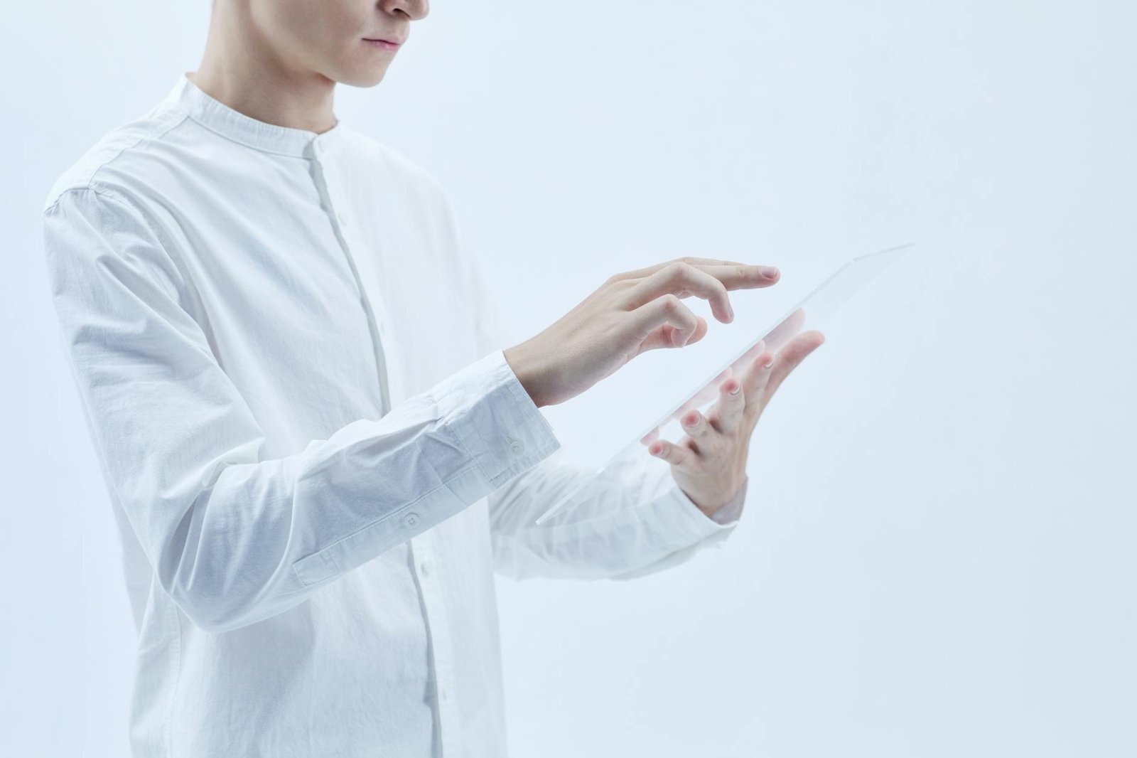 Person interacting with a transparent digital tablet, symbolizing technology and futurism.
