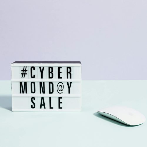 Minimalist setup featuring a Cyber Monday sale sign and computer mouse, perfect for online shopping themes.