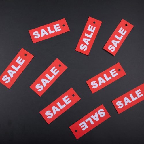 Red sale tags arranged on a dark background, ideal for retail promotions.