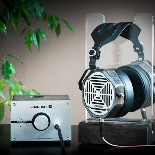 Close-up of high-end headphones and amplifier on a stand, showcasing modern audio technology.