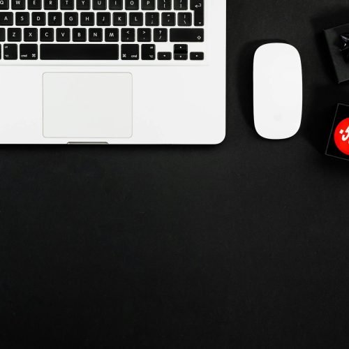 Minimalist flat lay featuring a laptop and shopping items with 50% sale tags.