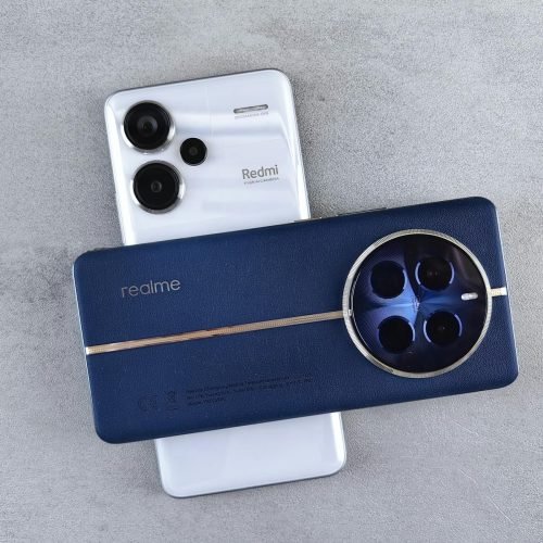 Flat lay of two modern smartphones with prominent camera designs on a concrete surface.
