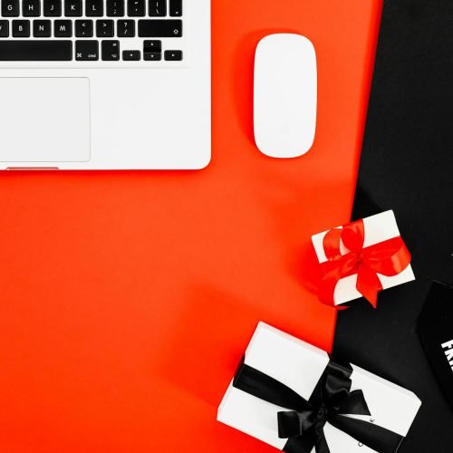 Modern flat lay of laptop and gift boxes for Black Friday shopping.