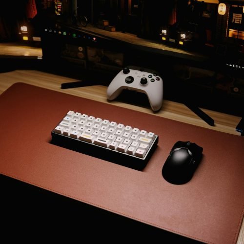 High-angle view of a sleek gaming setup featuring a mechanical keyboard and controller.