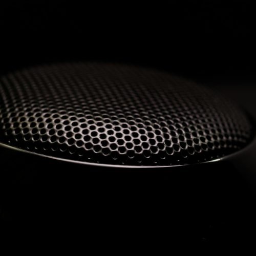 Detailed close-up of a black speaker grill, capturing its sleek and modern design