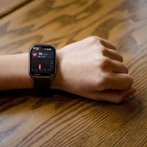 Close-up of a smartwatch displaying a heart rate of 90 bpm on a person's wrist.