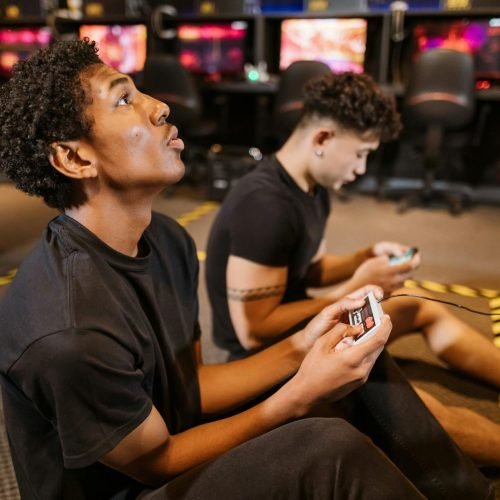 Two teenagers deeply engaged in a video gaming session at an indoor arcade.