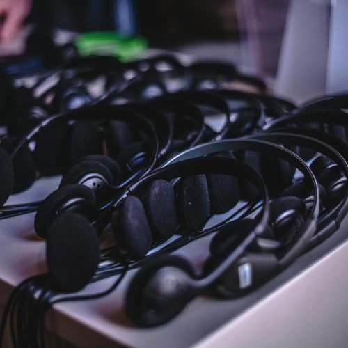 A variety of modern audio headsets neatly arranged on a display table indoors.