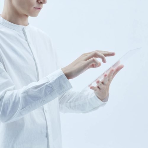 Person interacting with a transparent digital tablet, symbolizing technology and futurism.