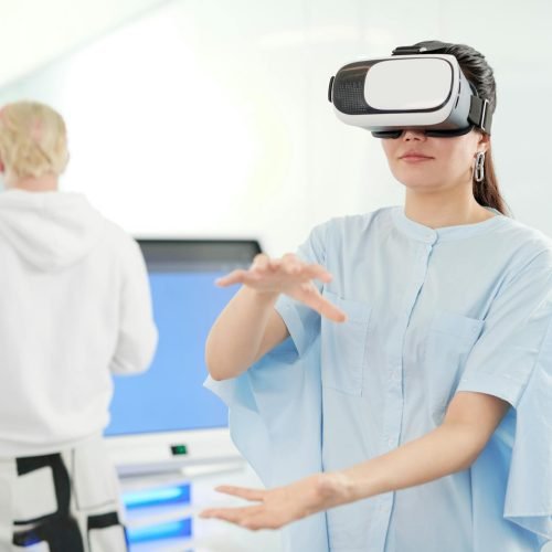 Woman in VR headset interacting in a modern office with tech devices in the background.