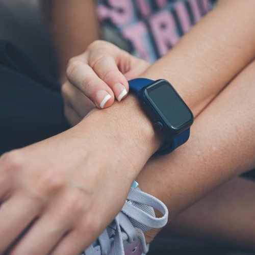 Woman wearing a smartwatch, adjusting its settings, close-up view.