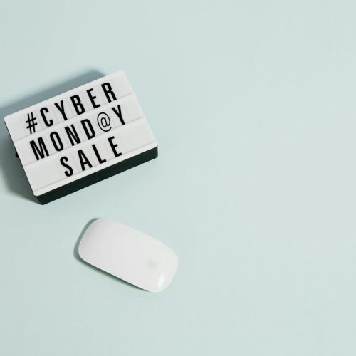 Minimalist design depicting Cyber Monday sale concept with a white mouse on pastel background.