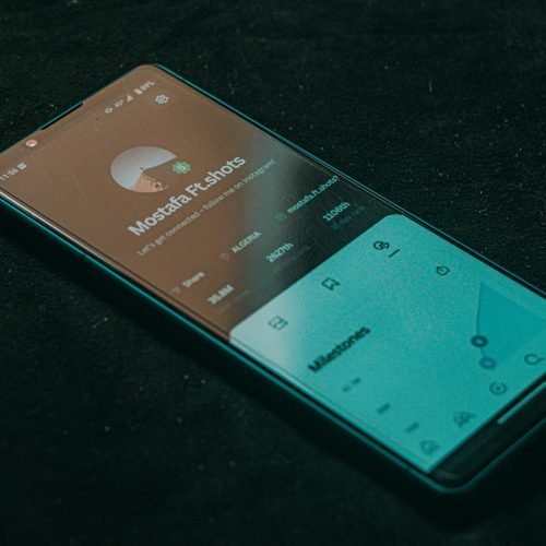 A smartphone displaying an app screen lies on a dark surface, highlighting technology.